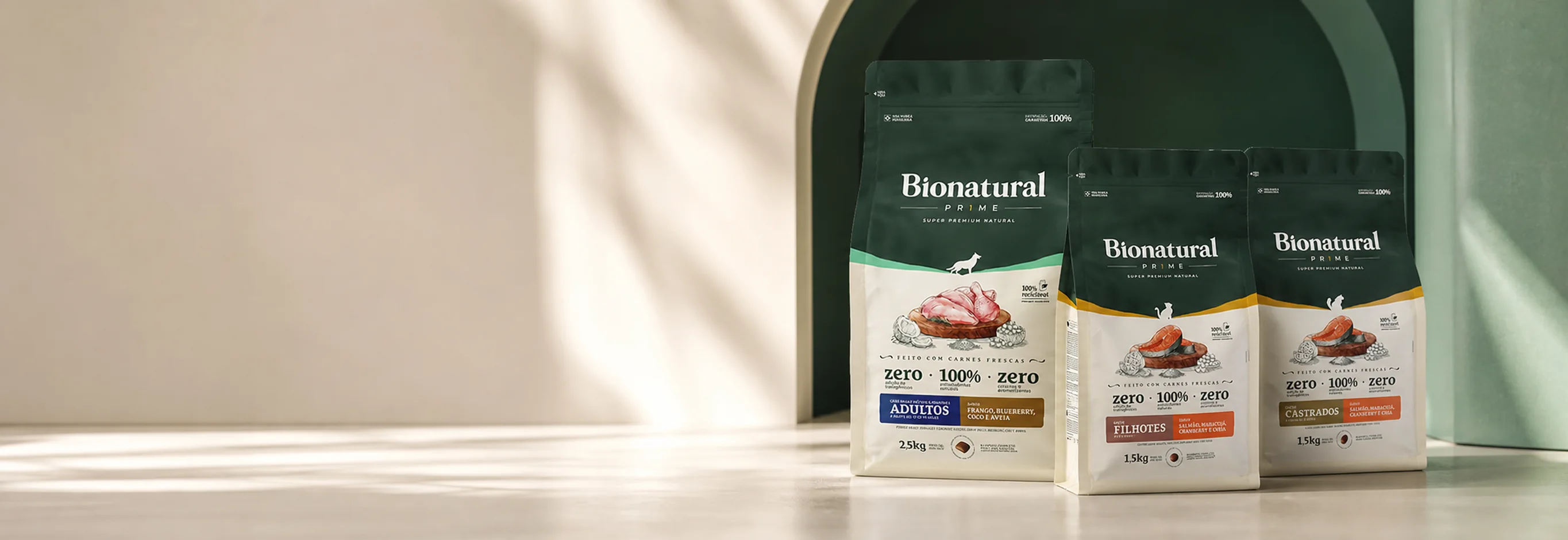 Tres bolsas de Bionatural Prime para perro y gato en una escena de estudio verde y marfil.